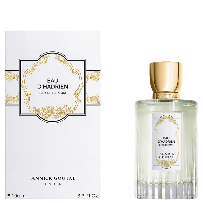 Eau de Parfum Eau d'Hadrien da Annick Goutal Paris. Frasco cilíndrico com líquido verde claro e tampa dourada. Caixa branca com ornamentos dourados e moldura decorativa. Volume: 100ml (3.3 Fl.Oz).