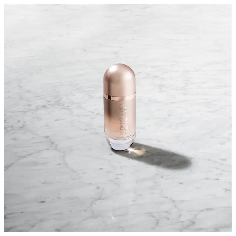 Frasco de perfume Carolina Herrera 212 VIP, com design elegante e minimalista em tons rosados, destacando o nome da marca e a numeração do produto.