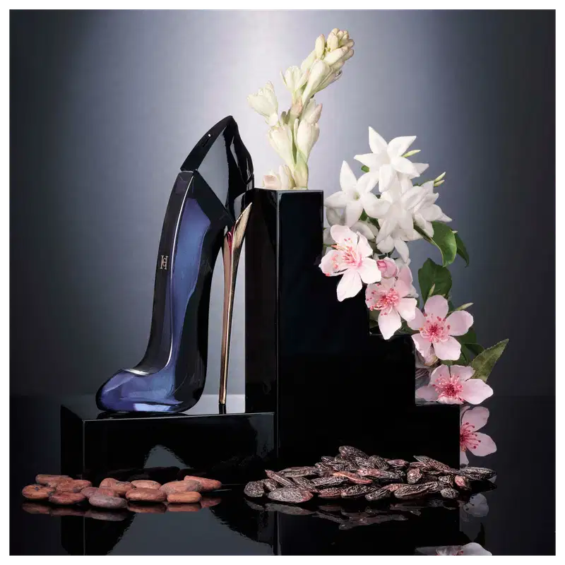 Frasco de perfume Carolina Herrera de design elegante e enigmático, com corpo preto brilhante e detalhes em dourado.