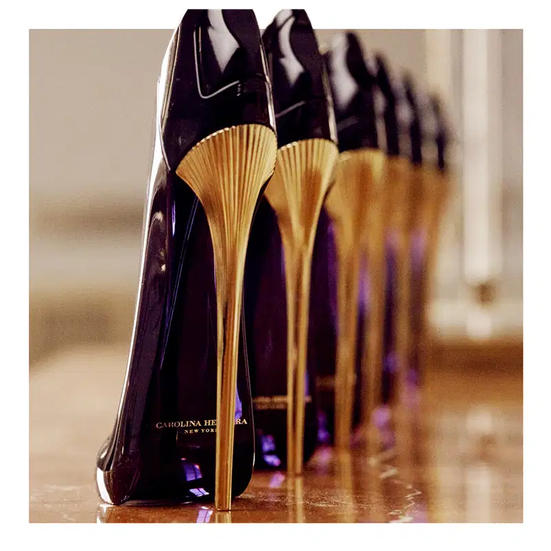 Frasco de perfume Carolina Herrera de design elegante e enigmático, com corpo preto brilhante e detalhes em dourado.