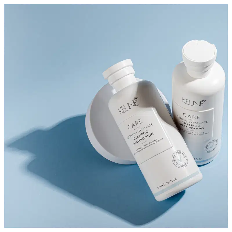 Frasco branco de shampoo Keune Care Derma Exfoliate, com rótulo em preto e branco indicando o nome do produto e sua função de remover caspa do couro cabeludo.