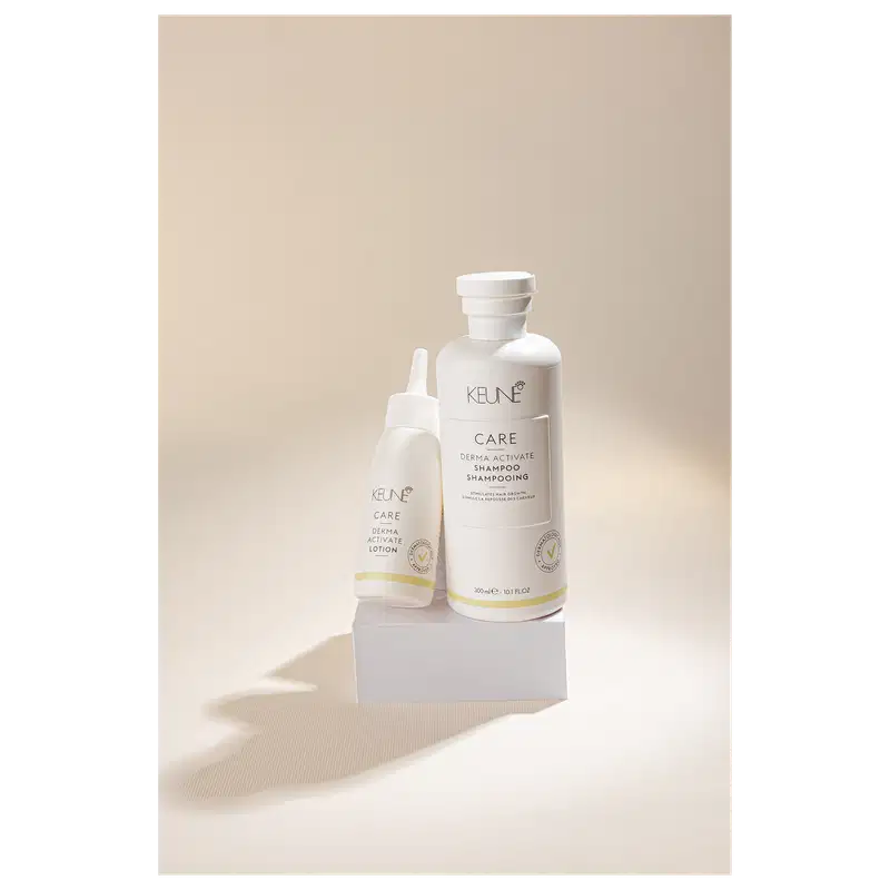 Frasco branco de loção ativadora Keune Care Derma Activate, com rótulo em preto e amarelo, apresentando informações sobre o produto.