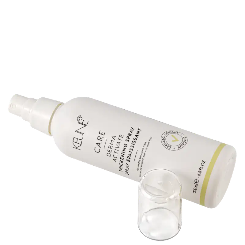 Frasco branco de 200 ml da linha Care da Keune, contendo o Spray Ativador de Espessura Derma Activate. O rótulo apresenta o nome do produto e sua função de volumizar os fios finos.