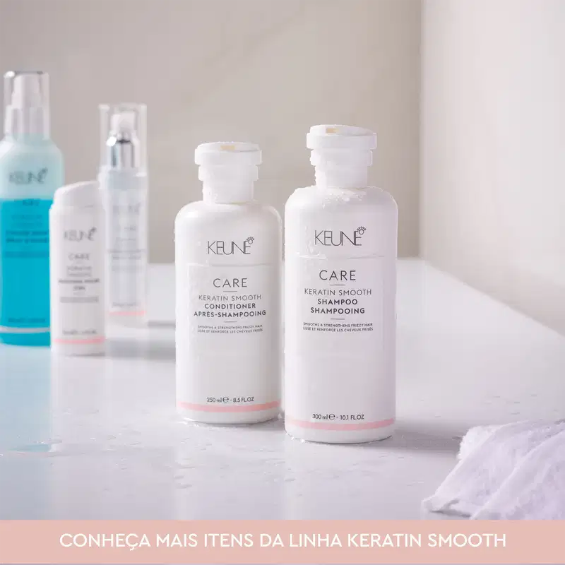 Ambiente de produtos de beleza da linha Keratin Smooth da marca Keune, com embalagens de shampoo e condicionador em tons de branco e rosa, em um cenário claro e minimalista.