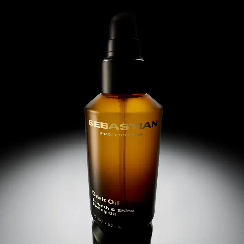 Embalagem de óleo escuro da marca Sebastian Professional, em fundo preto, com destaque para o nome da marca e a descrição "Dark Oil Growth & Shine Styling Oil". 
