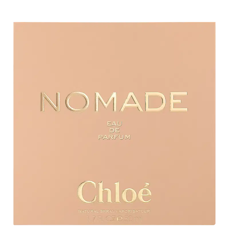 Caixa retangular em tons de bege e rosa claro. O nome "Nomade" está escrito em letras maiúsculas douradas, com a descrição "Eau de Parfum" abaixo em letras menores.