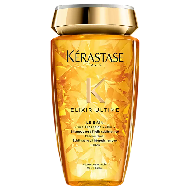 Frasco de shampoo da marca Kérastase Paris, com design dourado e rótulo destacando o nome "Elixir Ultime" e a descrição "Shampooing à l'huile sublimatrice", indicando um shampoo com óleo sublimador. O frasco possui 250 ml de capacidade.