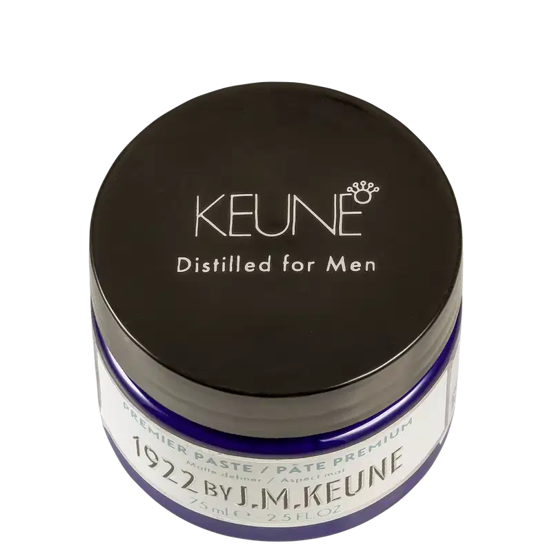 Frasco de pasta/pomada para homens da marca Keune, com embalagem preta e azul, exibindo o nome da marca e a descrição "Distilled for Men" em letras brancas.