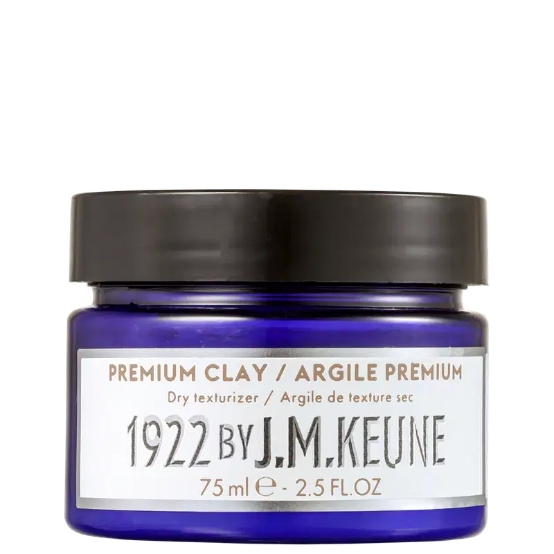 Frasco de cera modeladora da marca Keune, com tampa preta e rótulo branco com texto em dourado. O produto é descrito como um texturizador seco e a embalagem possui 75 ml.
