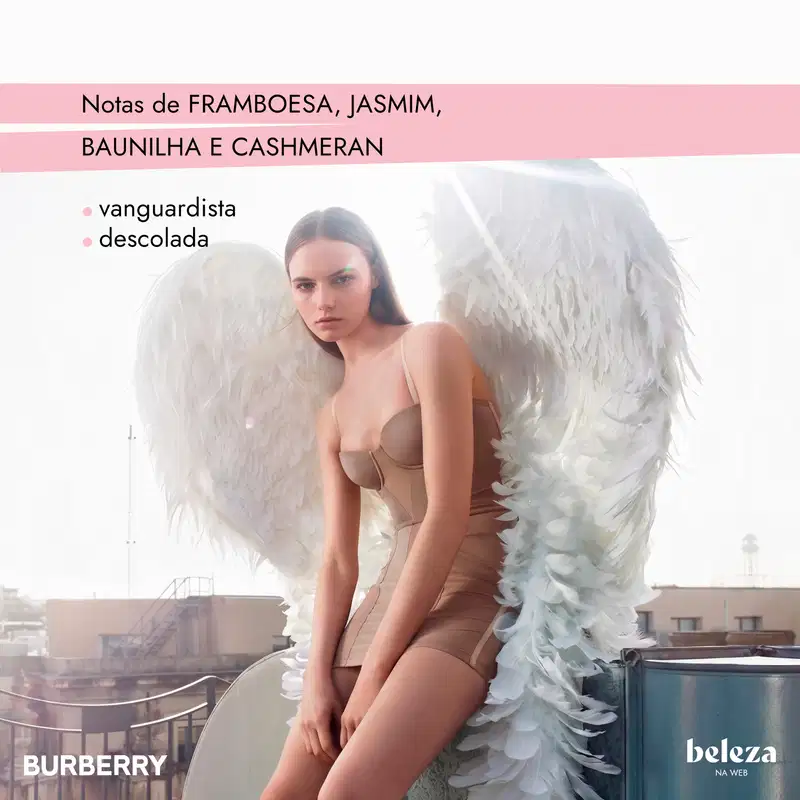 Uma mulher de cabelos escuros usa um conjunto de lingerie bege e asas brancas de plumas.