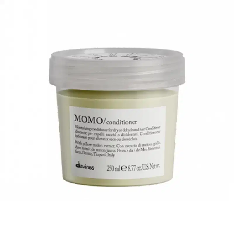 Frasco de condicionador Momo da marca Davines, com tampa transparente e rótulo branco com texto em preto. O produto contém extrato de melão amarelo e é indicado para cabelos secos ou desidratados.