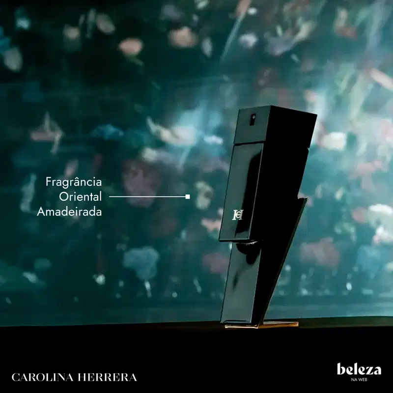 Frasco preto de perfume Carolina Herrera com rótulo "Fragrância Oriental Amadeirada" em fundo desfocado de folhas verdes.