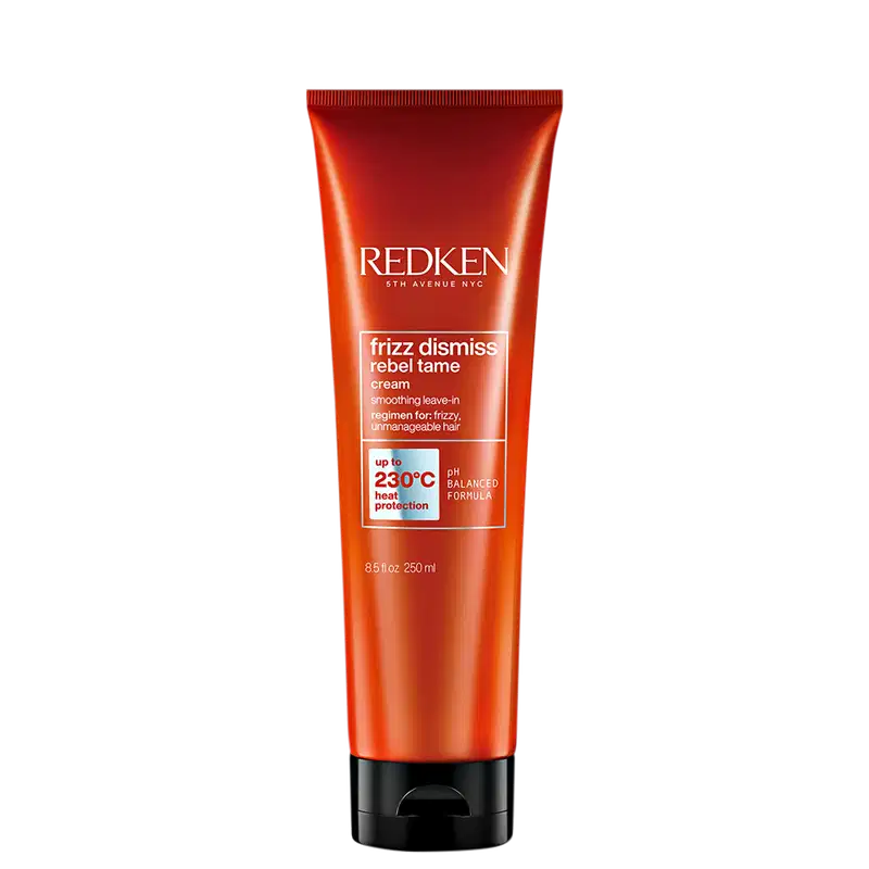 Tubo de creme para cabelos da marca Redken, com design vermelho e preto. Rótulo indica que o produto é da linha "Frizz Dismiss Rebel Tame" e promete controle de frizz com proteção térmica de até 230°C.