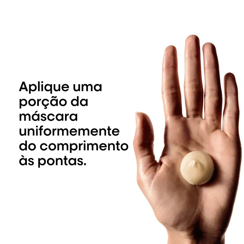 Produto de beleza em embalagem branca com texto em português, aplicado uniformemente sobre os dedos de uma mão, indicando o comprimento ideal da máscara capilar.