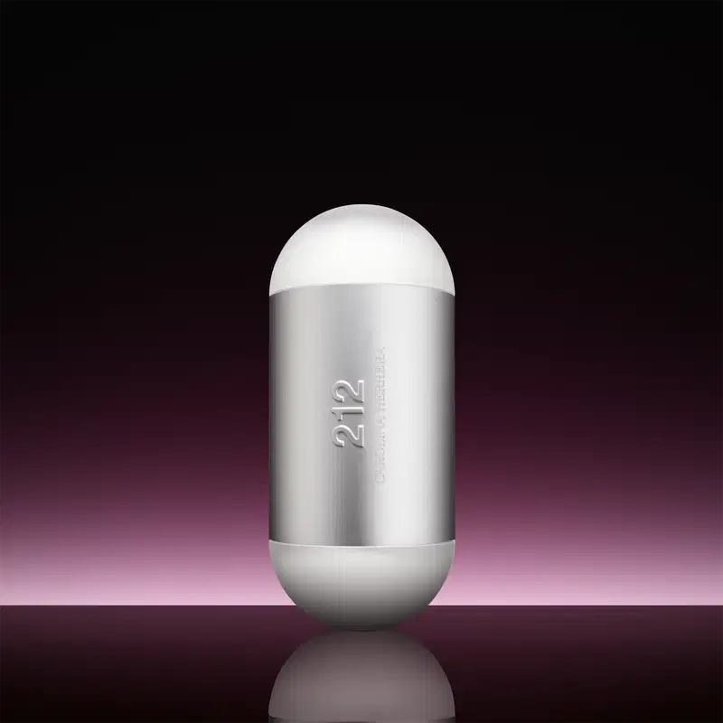 Frasco de perfume Carolina Herrera 212 em formato oval, com superfície prateada e detalhes em branco. O rótulo exibe o nome da fragrância em letras grandes.