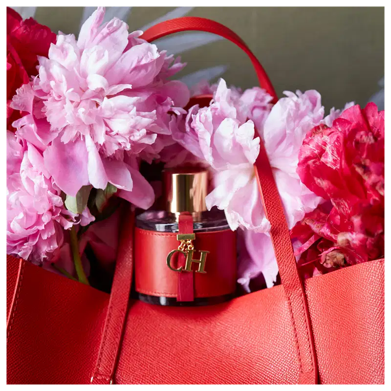 Frasco de perfume Carolina Herrera em embalagem vermelha com detalhes dourados, tampa dourada e logotipo da marca visível.