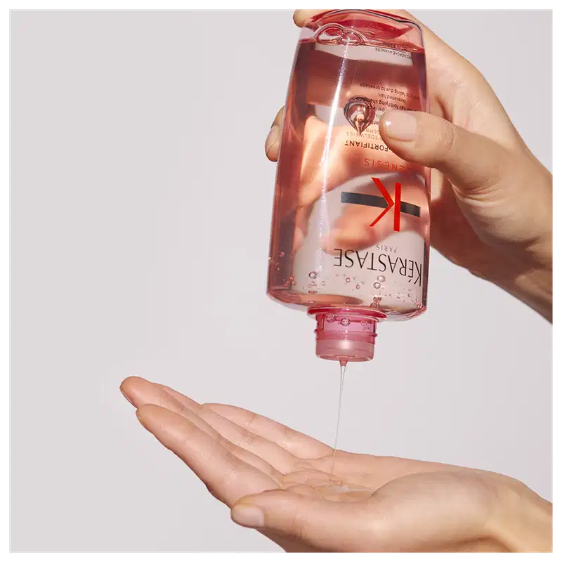 A mão segura um frasco de gel de limpeza facial da marca Neutrogena, com um líquido vermelho transparente escorrendo sobre a palma. O fundo branco e a embalagem vermelha e branca sugerem um ambiente de cuidados de pele e higiene pessoal.