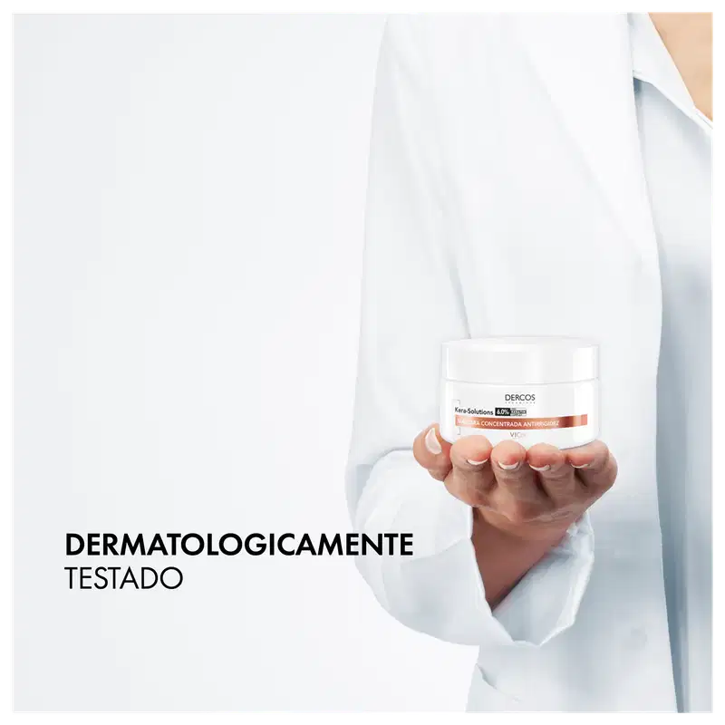 A imagem mostra um profissional de saúde segurando um produto da marca Dercos, que é uma linha de cuidados capilares da Vichy, uma marca de cosméticos e produtos de beleza.