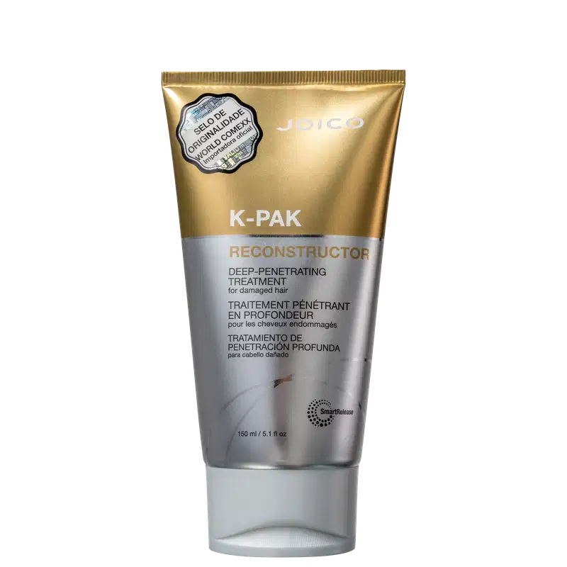 Trata-se de um frasco de tratamento capilar da marca Joico, chamado K-PAK Reconstructor. O produto é apresentado em uma embalagem dourada e prateada, com rótulo destacando suas propriedades de tratamento profundo e penetrante para cabelos danificados.