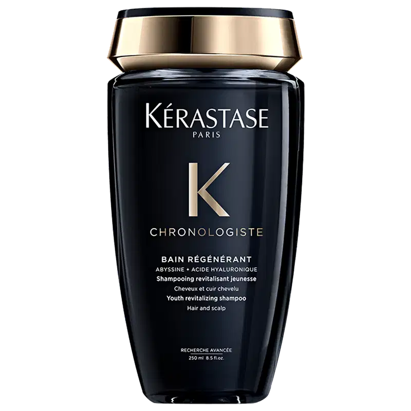 Frasco preto e dourado da linha Chronologiste da Kérastase, contendo um shampoo revitalizante para cabelos e couro cabeludo, com fórmula à base de abissina e ácido hialurônico.