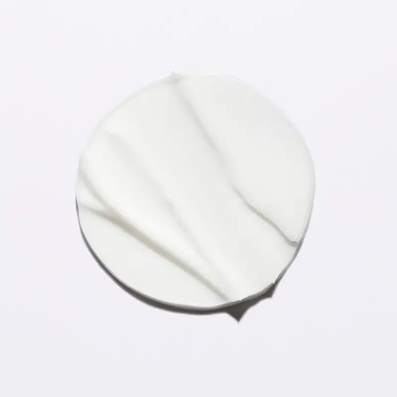 Textura cremosa e sedosa, com aparência suave e brilhante, típica de produtos Kérastase. Sua cor branca e uniforme sugere uma fórmula leve e delicada.