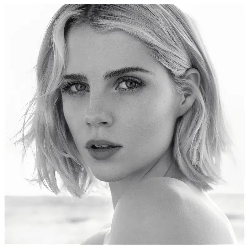 Retrato em preto e branco de uma mulher loira com cabelos curtos e olhar intenso, sugerindo um ambiente de beleza e glamour da marca Chloé.