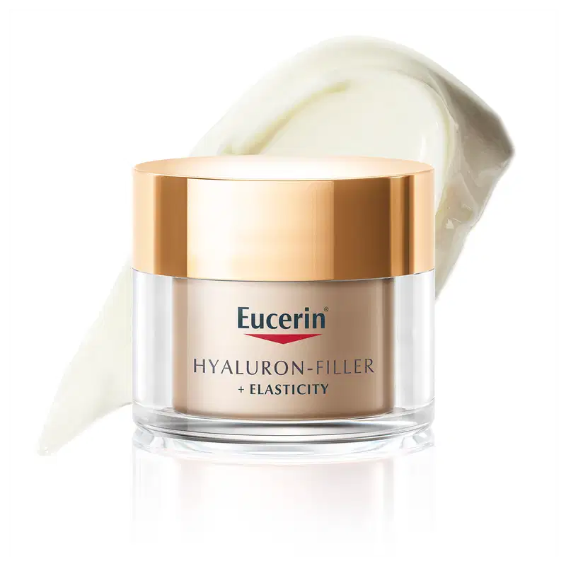 Pote de creme facial da marca Eucerin com textura cremosa e acabamento brilhante, em embalagem de vidro com tampa dourada, sobre superfície clara.