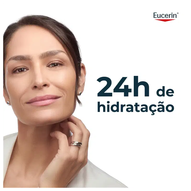 Uma mulher madura com cabelos escuros e expressão séria, com a marca Eucerin visível no canto superior direito da imagem, que apresenta o texto "24h de hidratação" em destaque.