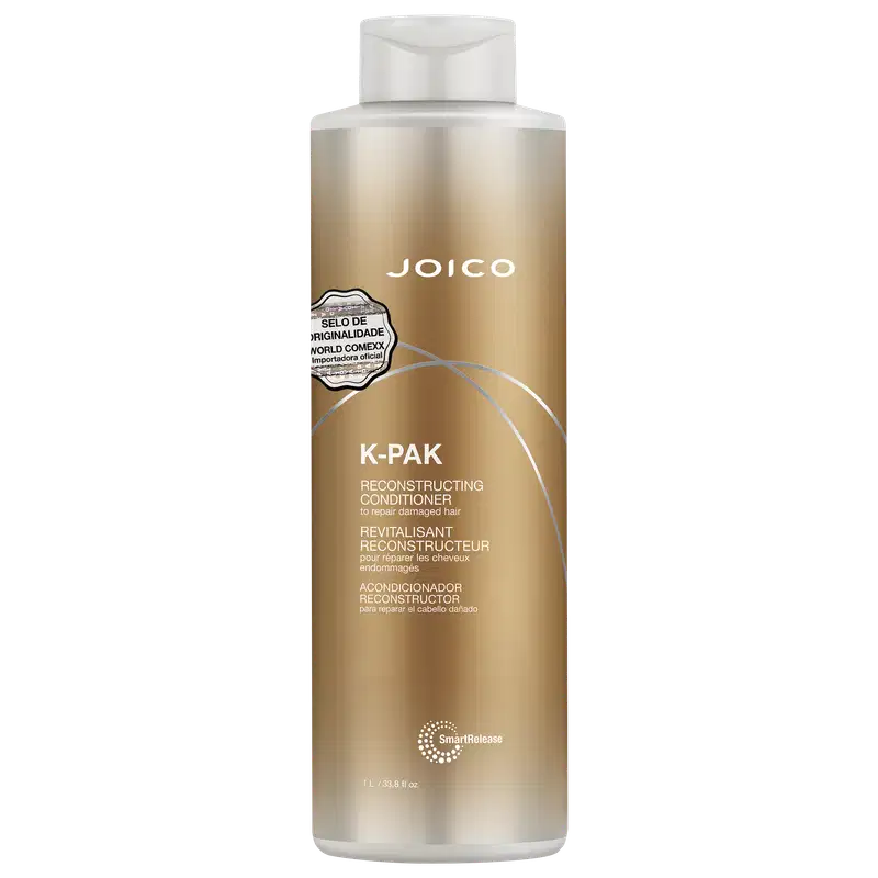 Frasco de condicionador de 1 Litro da marca Joico, da linha K-Pak, com embalagem em tons dourados e brancos. O rótulo destaca o "Selo de Originalidade World Comexx" e a função de reconstrução do produto.