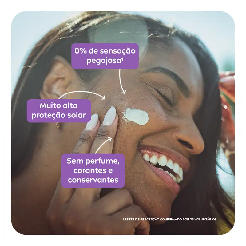 A imagem mostra uma mulher sorridente aplicando o protetor solar no rosto, evidenciando sua textura leve e não oleosa.