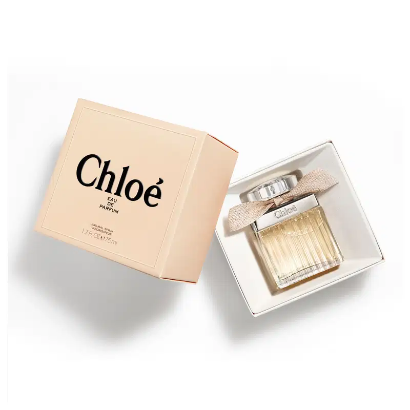 Frasco de perfume Chloé com tampa prateada e laço bege, apresentando o nome da marca em destaque. O design elegante e minimalista transmite sofisticação.