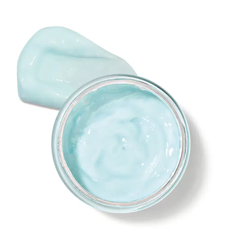 Pote transparente com gel de cor azul-esverdeada, posicionado sobre uma superfície clara.