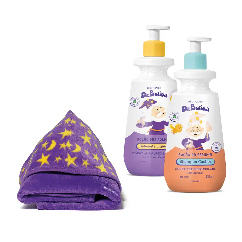 Dois frascos de produtos infantis da marca Dr. Botica, sendo um sabonete líquido e um shampoo para cachos em embalagens brancas com válvula pump e detalhes em laranja no shampoo e roxo no sabonete e um roupão roxo com estrelas e luas amarelas dobrado.