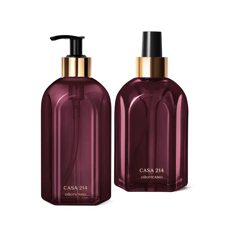 A imagem mostra dois itens da marca Casa 214 Figo Magnífico:  são dois vidros na cor roxa com detalhes em dourado, um de sabonete líquido com bomba dosadora preta e outro de aromatizador de ambientes com válvula spray também preta.