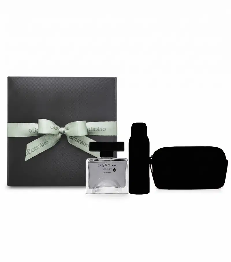 Caixa de presente cinza com laço verde-claro com logo oBoticário e  frasco de fragrância transparente da linha Coffee Man Lucky, além de silhueta de dois itens surpresa, conjunto de itens de perfumaria da marca Boticário.