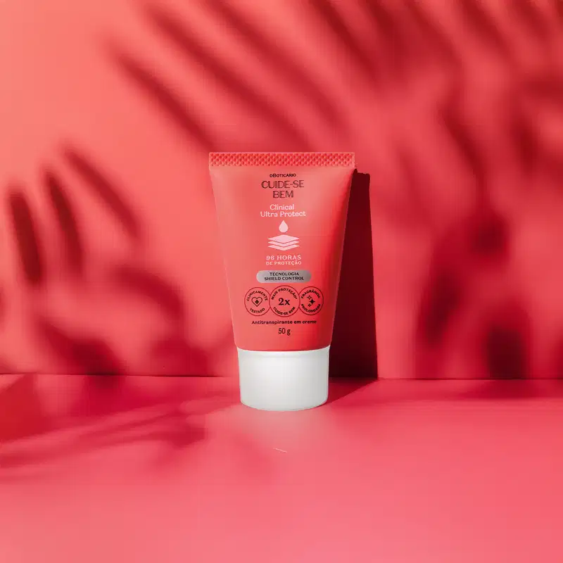Bisnaga laranja com tampa branca, detalhe azul e letras pretas e brancas, contendo 50g de antitranspirante em creme da marca Cuide-se Bem Clinical Ultra Protect em um fundo laranja com sombras.