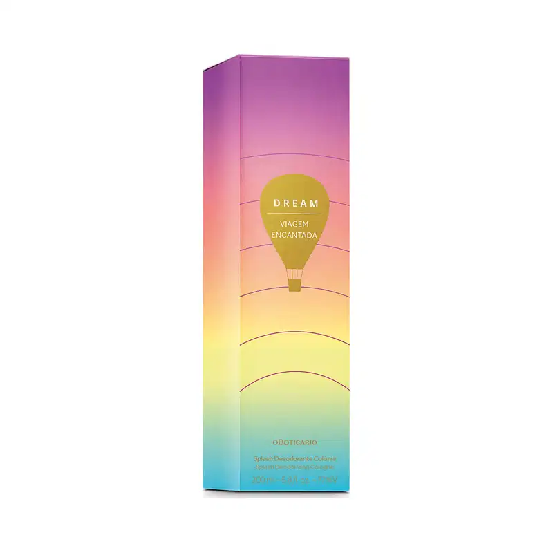 Imagem de embalagem retangular em tons de roxo, rosa e amarelo com ilustração de balão de ar quente e texto "Dream Viagem Encantada" em destaque. Contém um frasco de 200 ml de body splash.