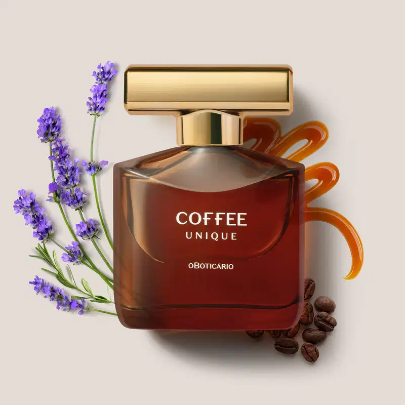 Imagem de um frasco em tom marrom contendo desodorante colônia da marca Coffee Man Unique sobre superfície clara, com flores de lavanda e grãos de café e um rastro de caramelo ao redor.