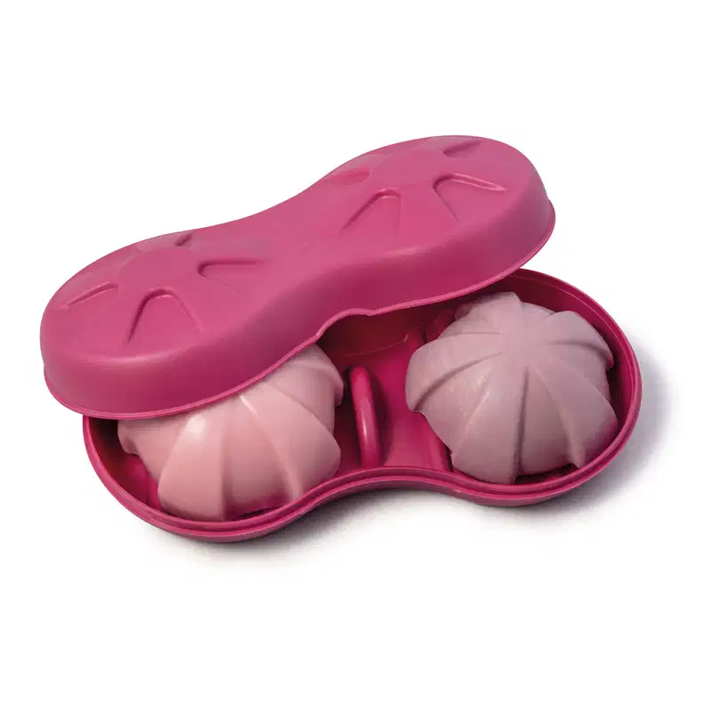 Base para sólidos na cor rosa da marca Nativa SPA, ideal para produtos em barra. O produto tem duas partes arredondadas para acomodar os itens. Dentro dele, é possível ver dois itens em barra, um na cor rosa e outro na cor roxa.