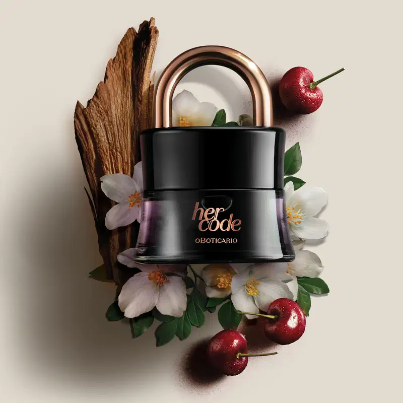 Na imagem, o produto está cercado por elementos naturais como um galho de madeira envelhecido, flores brancas, folhas verdes e cerejas vermelhas brilhantes. A composição remete a ingredientes naturais e botânicos usados na formulação do produto.