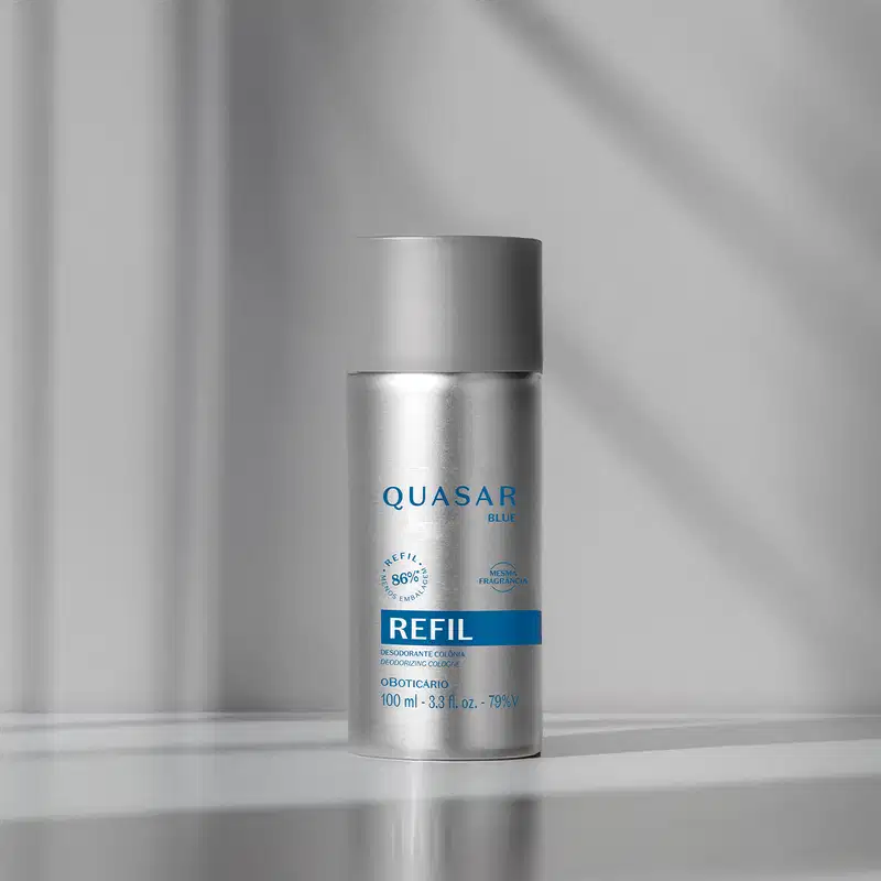 Refil de desodorante colônia Quasar Blue  em embalagem cilíndrica de metal prateado em fundo cinza com luzes.