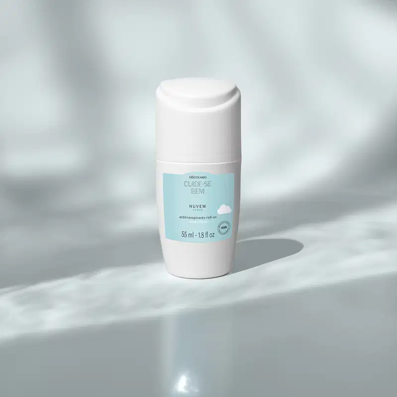 Frasco branco com rótulo azul claro e nuvens ilustradas contendo 55ml de antitranspirante roll-on Cuide-se Bem Nuvem em cenário claro com sombras.