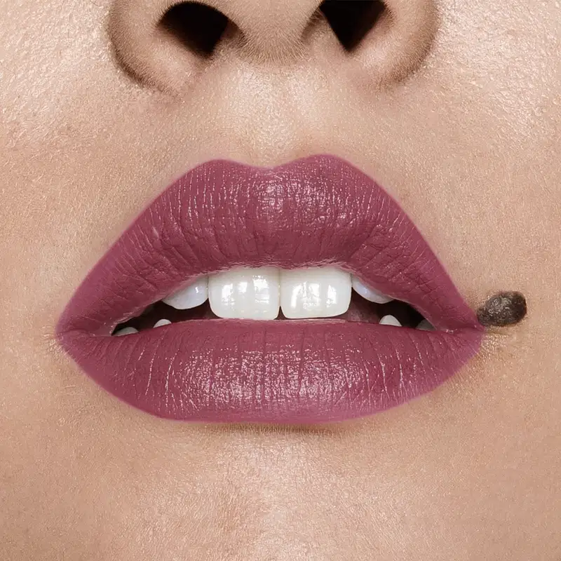Close-up de um rosto feminino evidenciando os dentes brancos e os lábios em tom de rosa intenso que usa o batom cremoso na cor rosa 250 da marca Intense