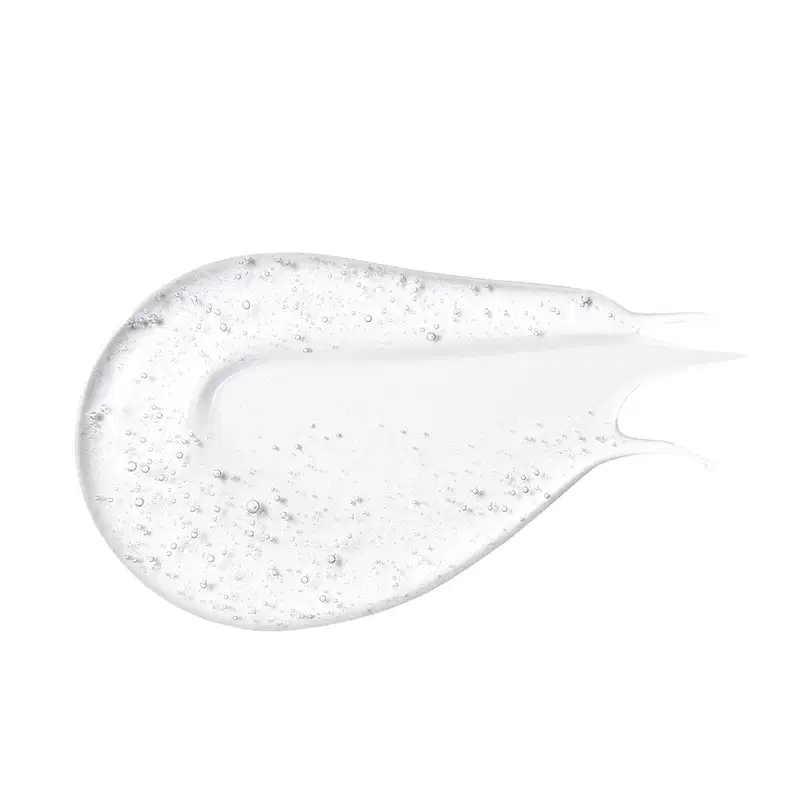 Textura gelatinosa e transparente do gloss labial incolor da marca Intense com pequenas bolhas no produto, aplicada em superfície branca e lisa.