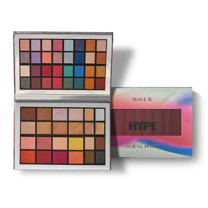 Paleta de maquiagem multifuncional Real Hype da marca Make B. em estojo prateado e 56 cores variadas. Ao lado, um estojo fechado em tons de branco, azul e rosa.