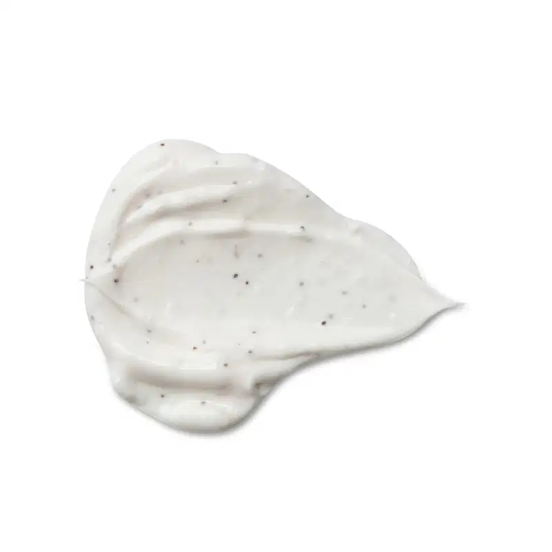 Textura cremosa e brilhante do creme esfoliante corporal Cuide-se Bem Feira Coco com pequenos pontos escuros dispersos, em fundo branco.