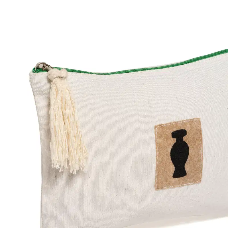 Nécessaire retangular de tecido bege com zíper, pingente e detalhe marrom com o logo da marca O Boticário em preto na frente do produto.