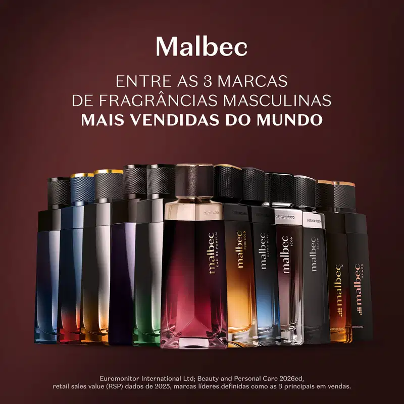Diversos frascos de desodorantes colônias da marca Malbec, em diferentes cores e formatos, dispostos sobre uma superfície escura em ambiente com iluminação avermelhada.