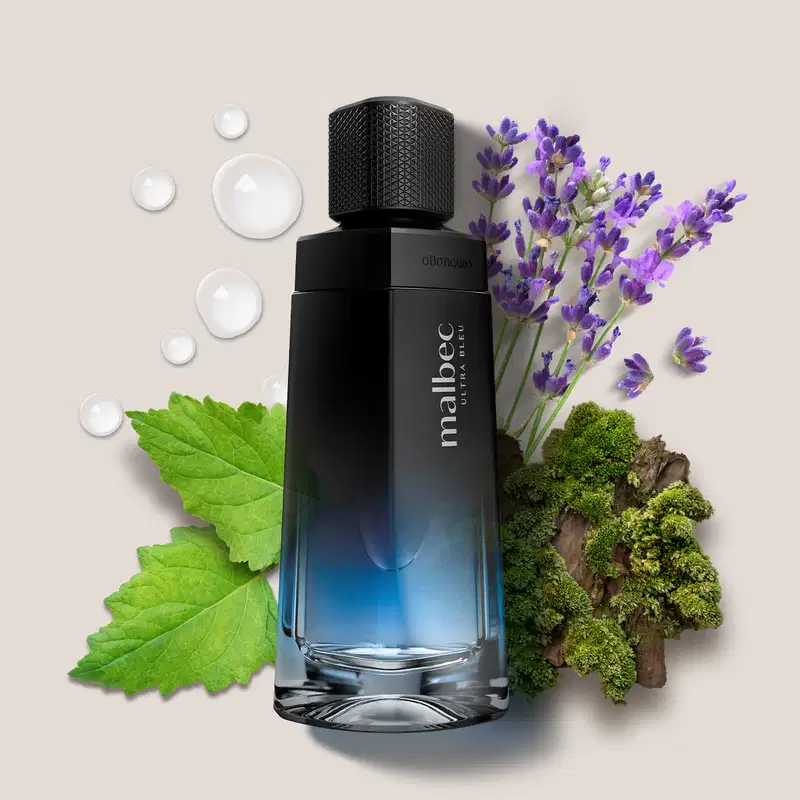 Imagem de um vidro azul e preto do Malbec Ultra Bleu e, ao redor do frasco, há elementos naturais como folhas verdes, flores de lavanda e pequenos pedaços de musgo, criando uma composição visual harmoniosa.
