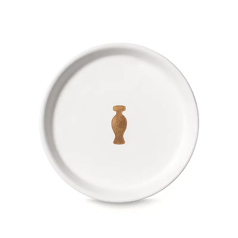Suporte para vela branco da marca Casa 214 no formato redondo com logo do Boticário em dourado no centro.